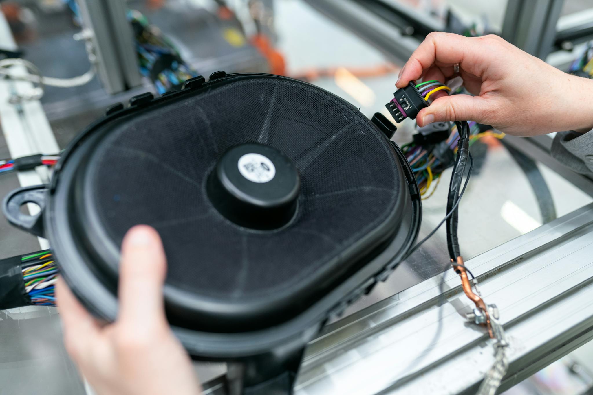Close-up of an engineer working on a sound system speaker assembly in a workshop.